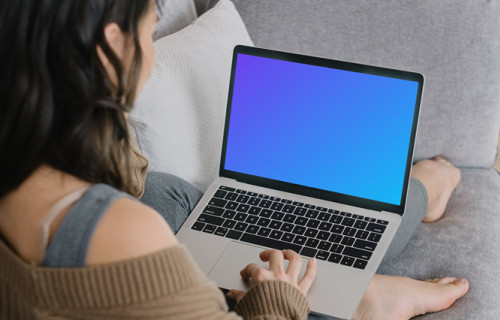 MacBook Pro mockup on a lady’s lap laying on a couch