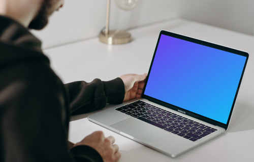 MacBook Pro mockup on a white table facing a mirror