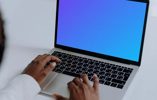 MacBook Pro mockup on a white table used by woman