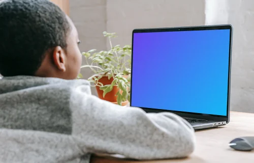 Un jeune garçon utilise un MacBook Pro mockup