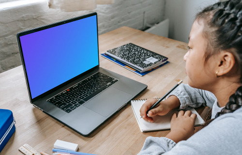 Young girl studying with a gray MacBook Pro mockup