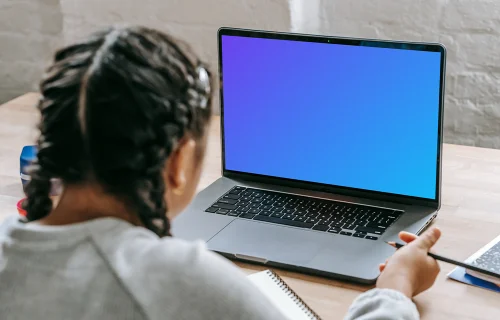 Young girl studying with a MacBook Pro mockup