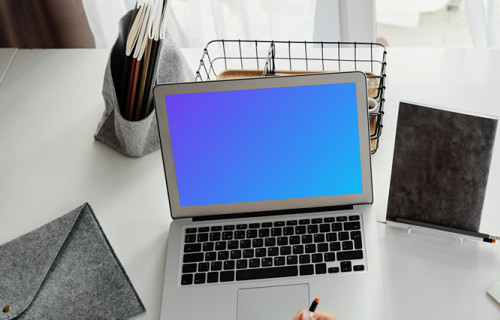 Young girl using a MacBook Air with a bag by the side mockup