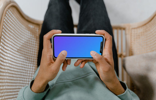 Close up of user holding iPhone mockup in landscape mode
