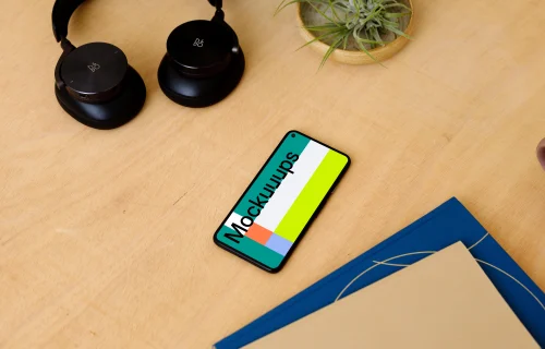 Google Pixel 5 on a table with a pair of headphones at the side