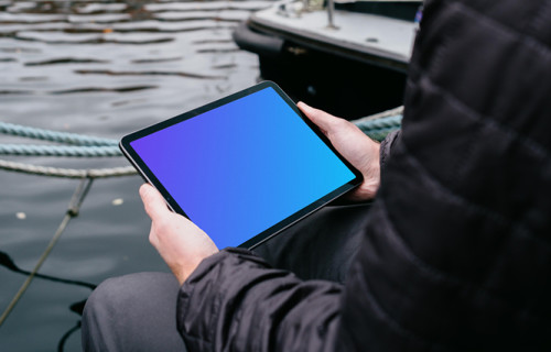iPad Air mockup held by a user beside a river