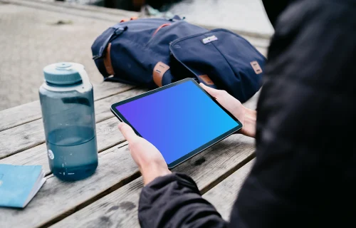 iPad Air mockup held by user next to a bag