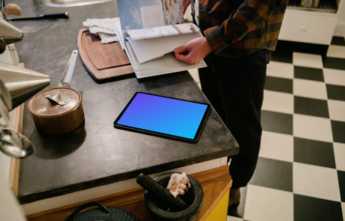 iPad Air mockup on a kitchen table beside a male user.