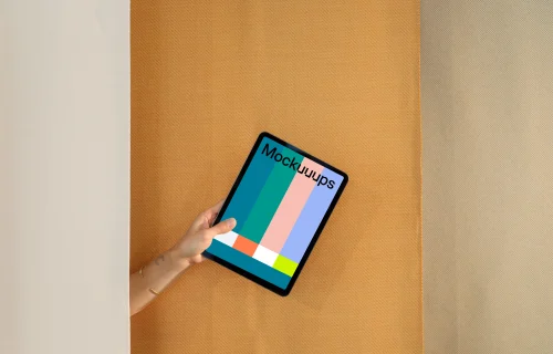 iPad Air mockup with a person holding it against a dual-tone backdrop