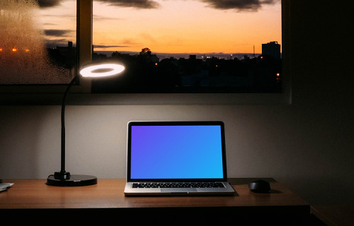 MacBook mockup at night with a reading lamp shining over it