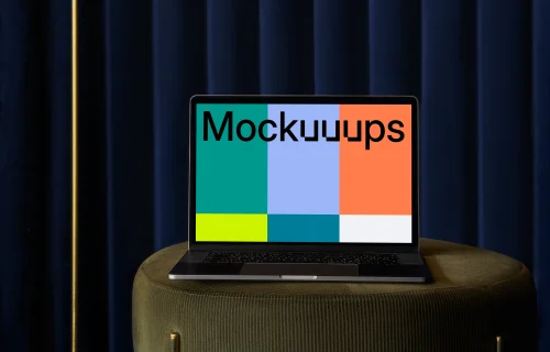 MacBook mockup on a sofa stool with blue curtain in the background