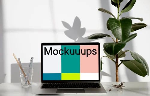 MacBook mockup on a white table with hard root plant at the side