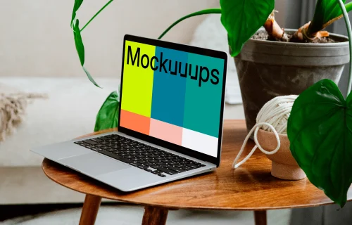 MacBook mockup on a wooden table with flower pot