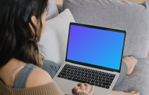 MacBook Pro mockup on a lady’s lap laying on a couch