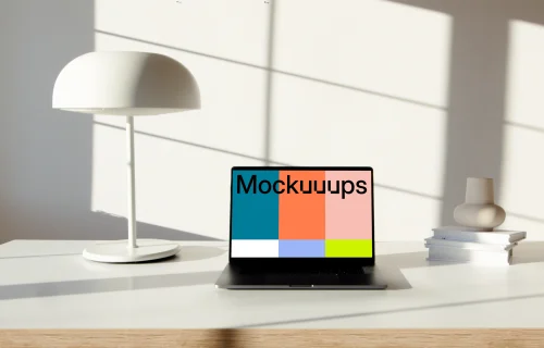 MacBook Pro mockup on a table beside a bright bulb