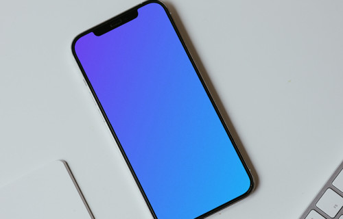 Minimal iPhone mockup on a white table with a wireless keyboard by the side