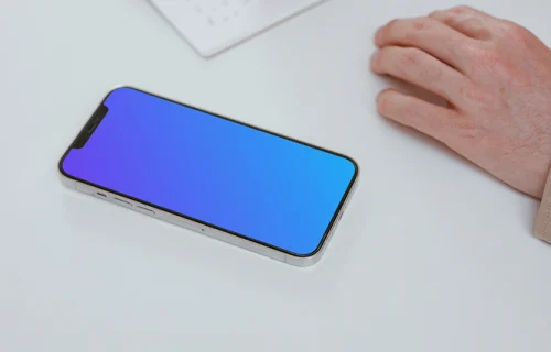 Simple iPhone mockup on a white table with a user writing by the side