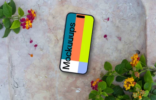 Smartphone mockup on a stone surface with flowers