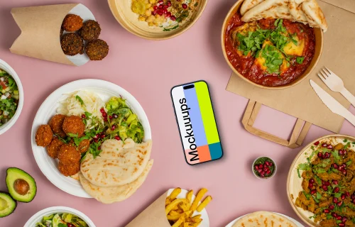 Smartphone mockup surrounded by selection of delicious Middle Eastern dishes