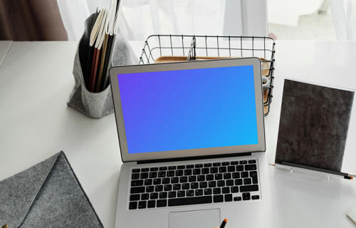 Young girl using a MacBook Air with a bag by the side mockup
