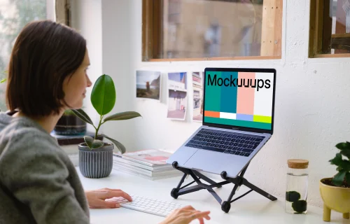 Young woman working on the Macbook Pro mockup in the bright office