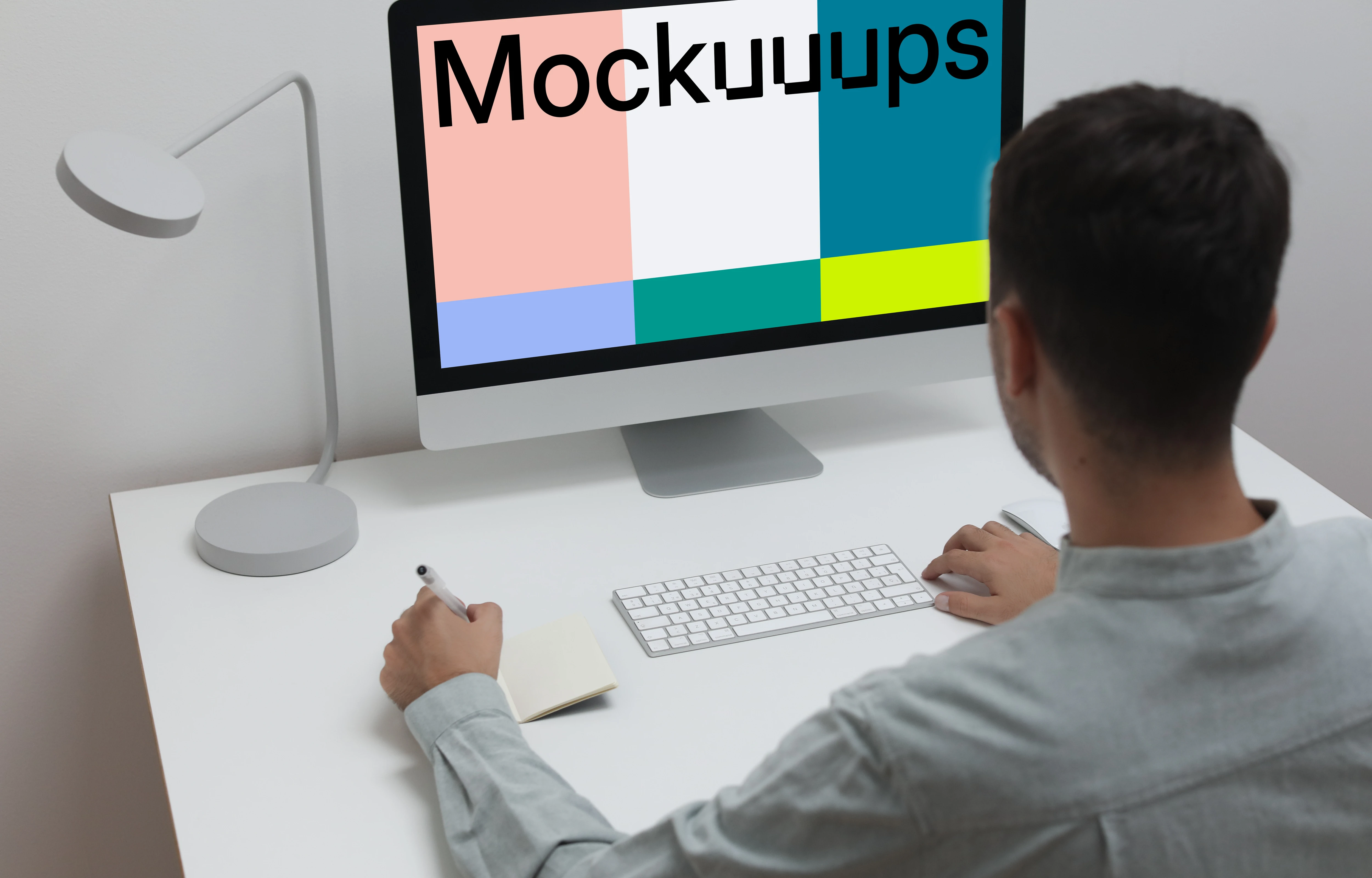 Mockup of man using iMac on a white table in a home office setting