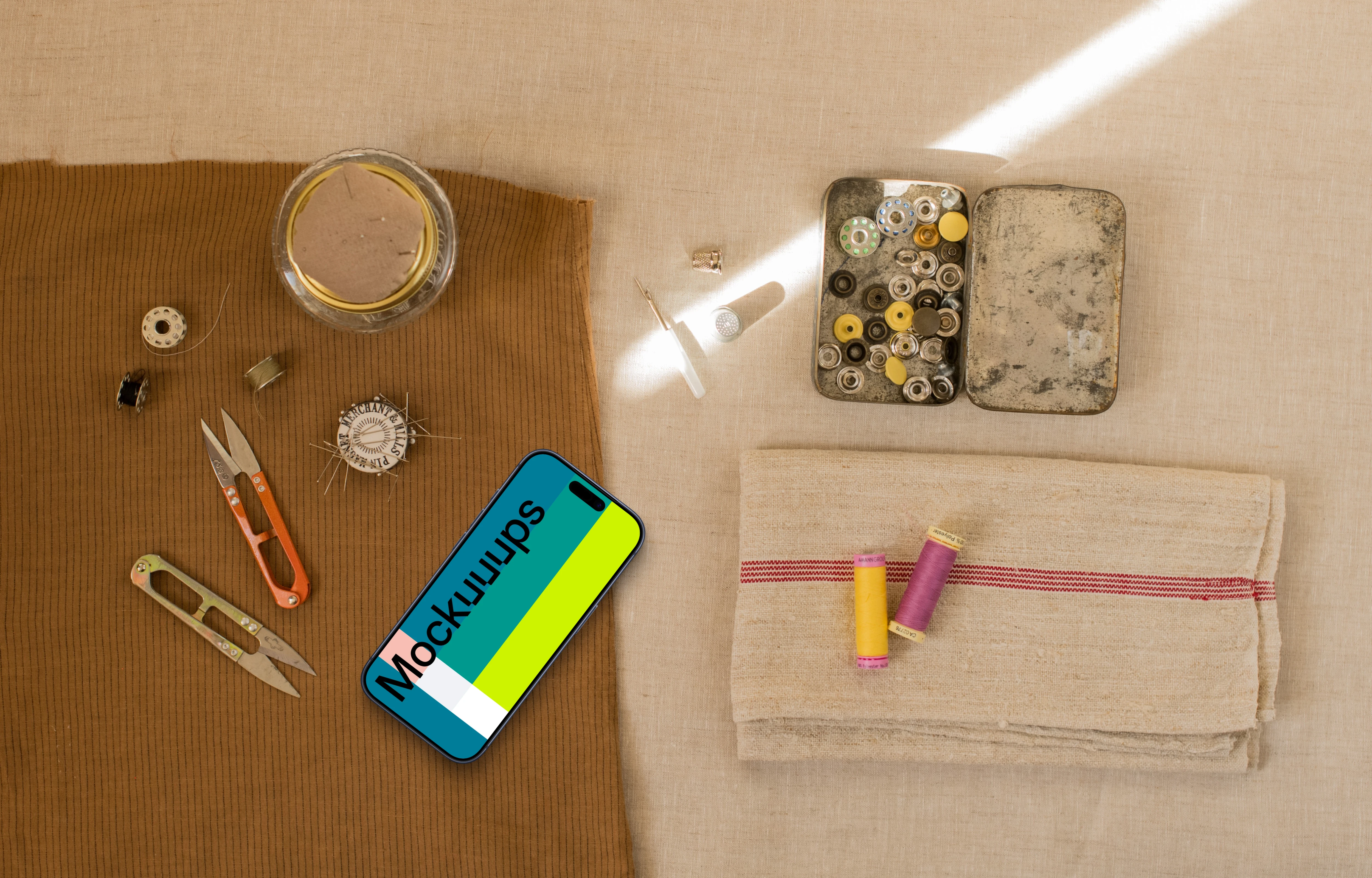 Smartphone mockup next to sewing accessories