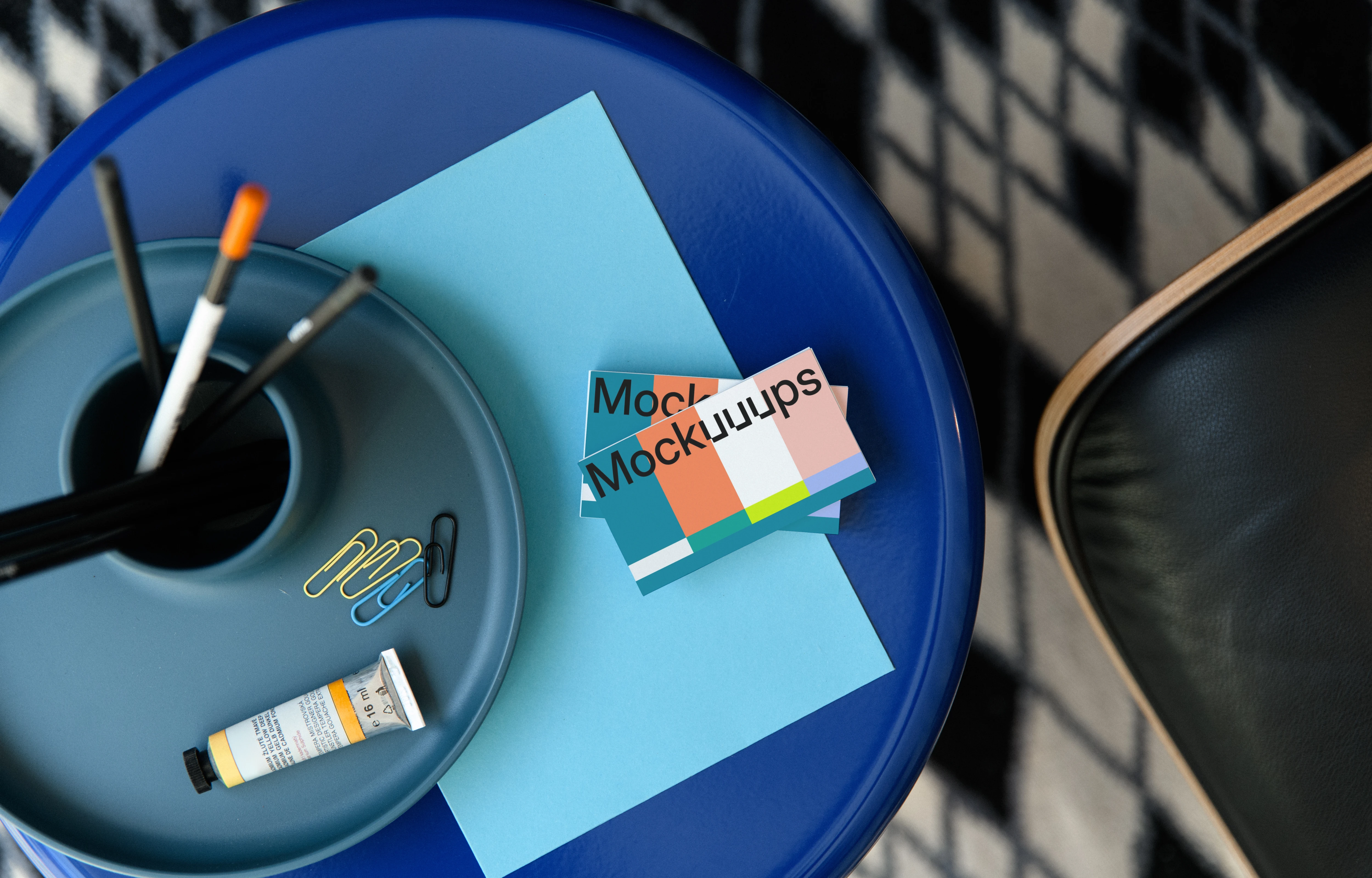 Business card mockup on a blue table with stationery