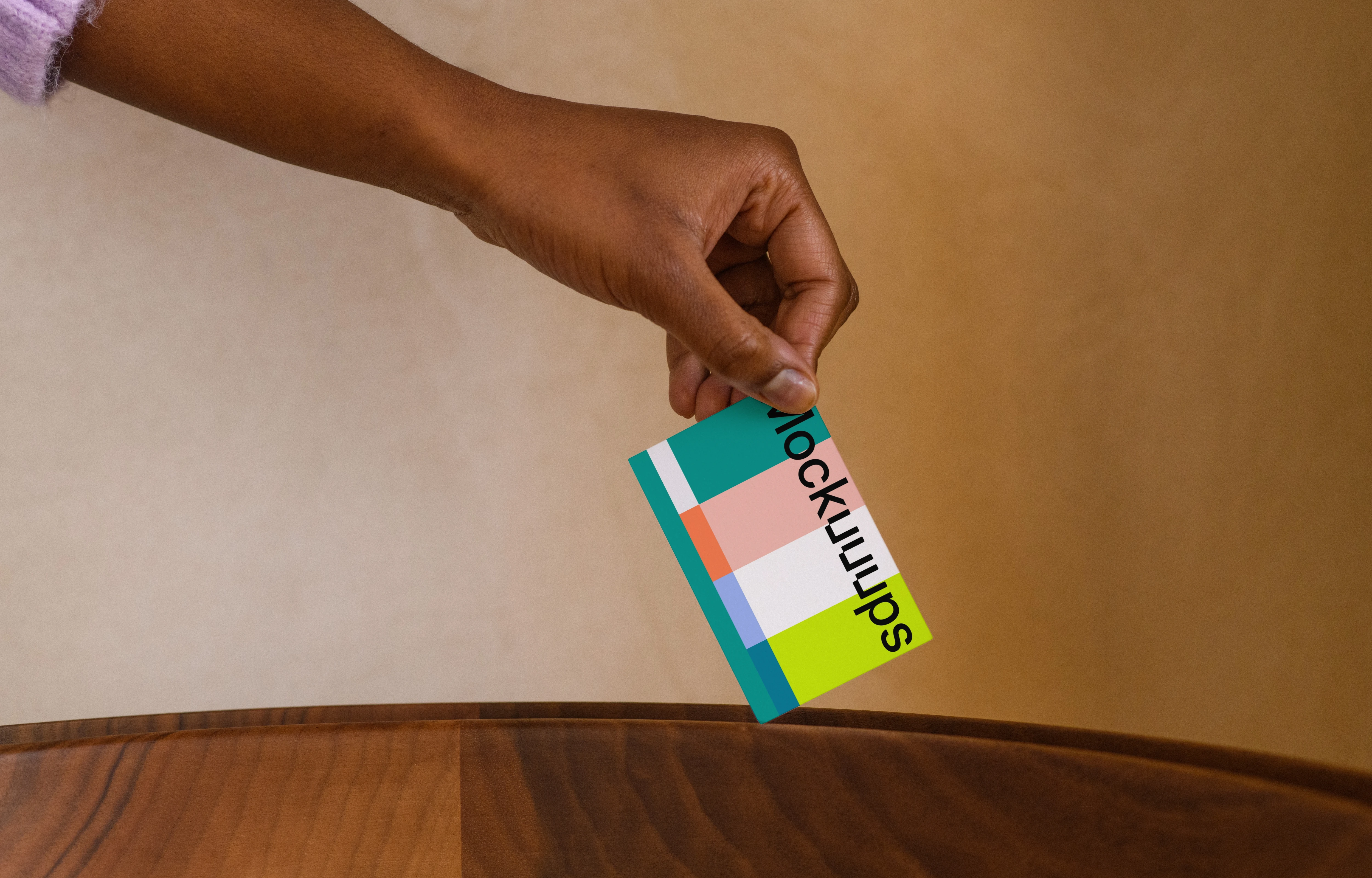 Business card mockup with hand over wooden surface