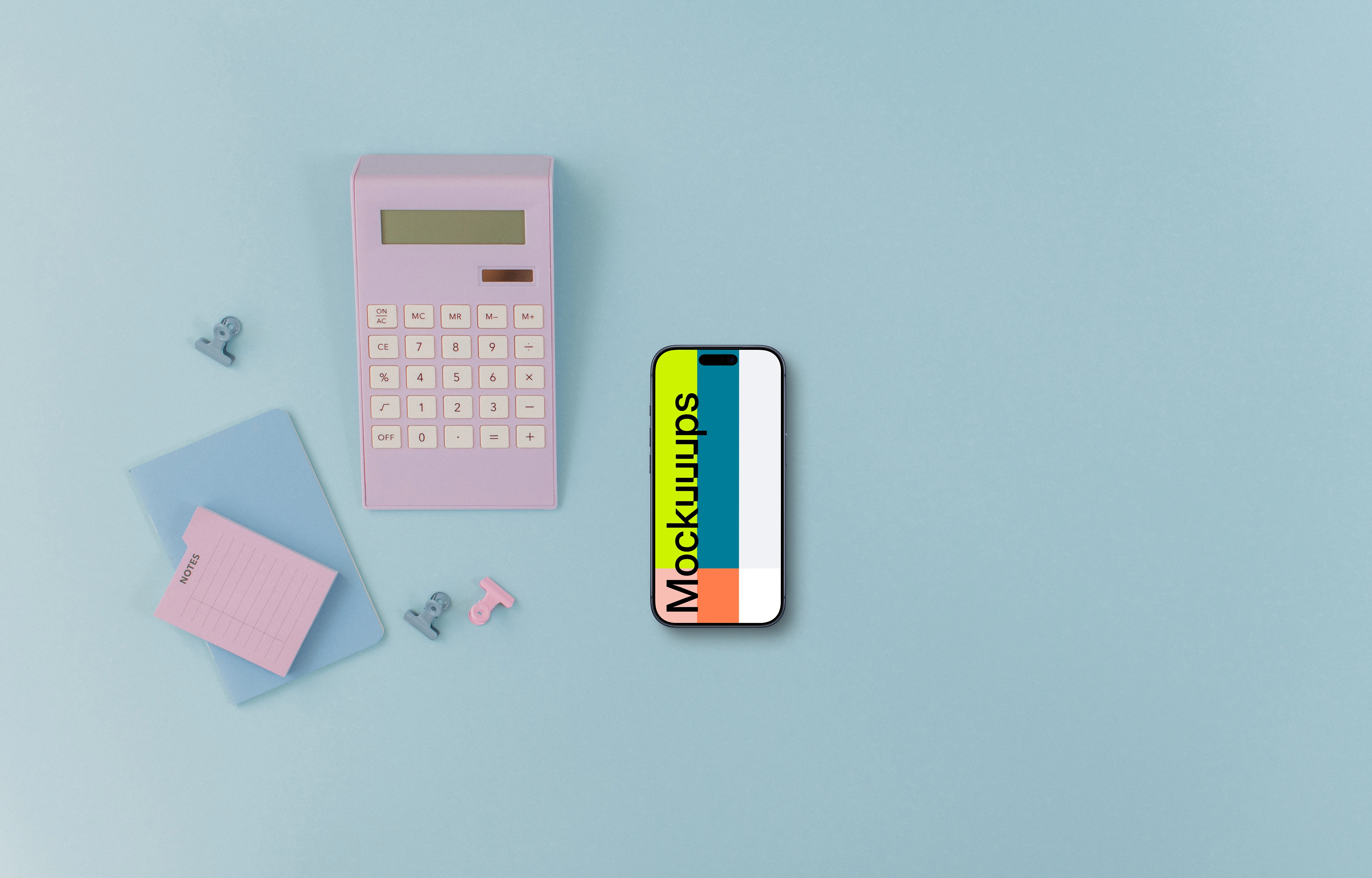 Calculator, small notebook and an iPhone on blue background