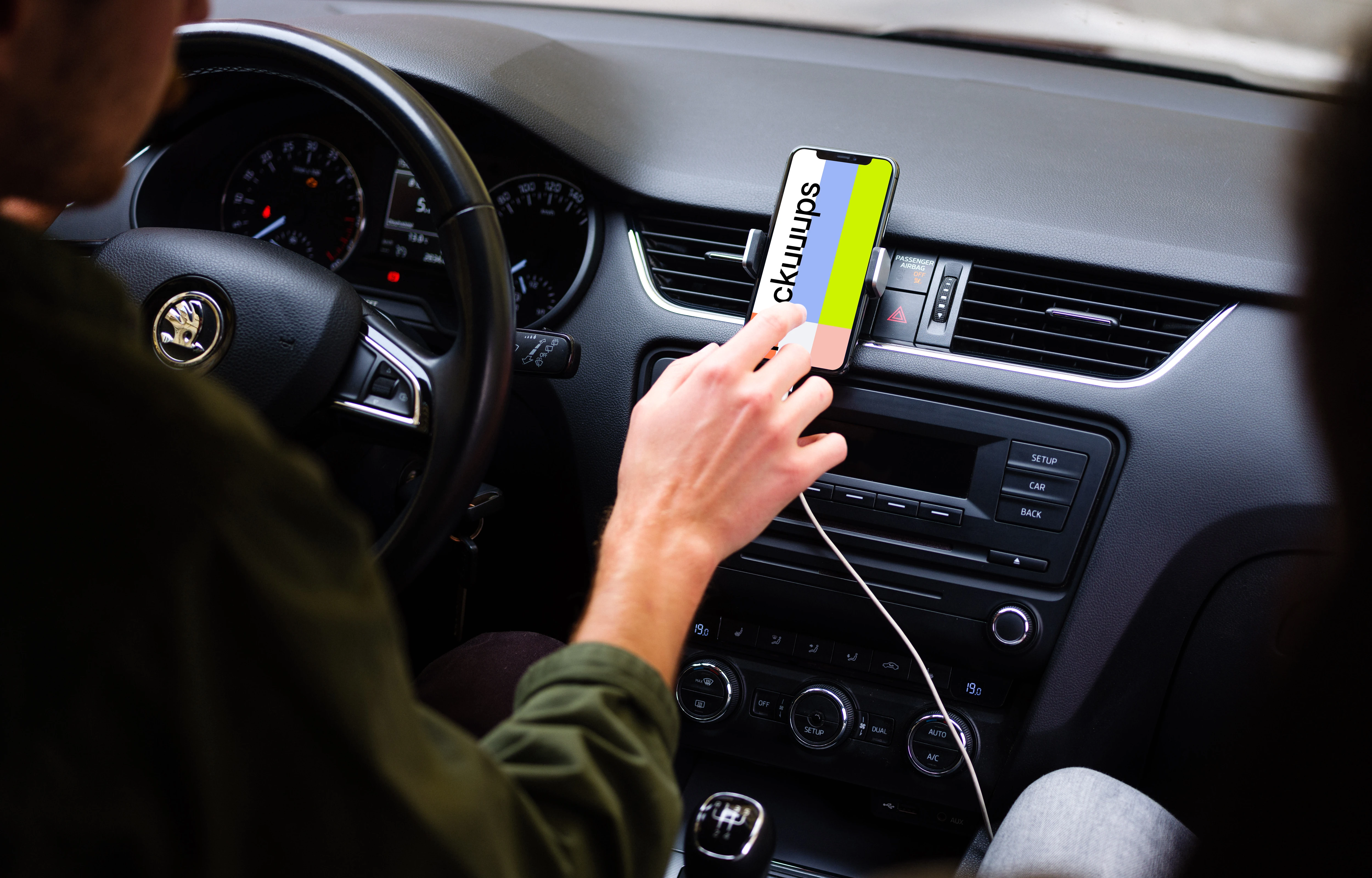 Car driver tapping iPhone 11 mockup in parked car