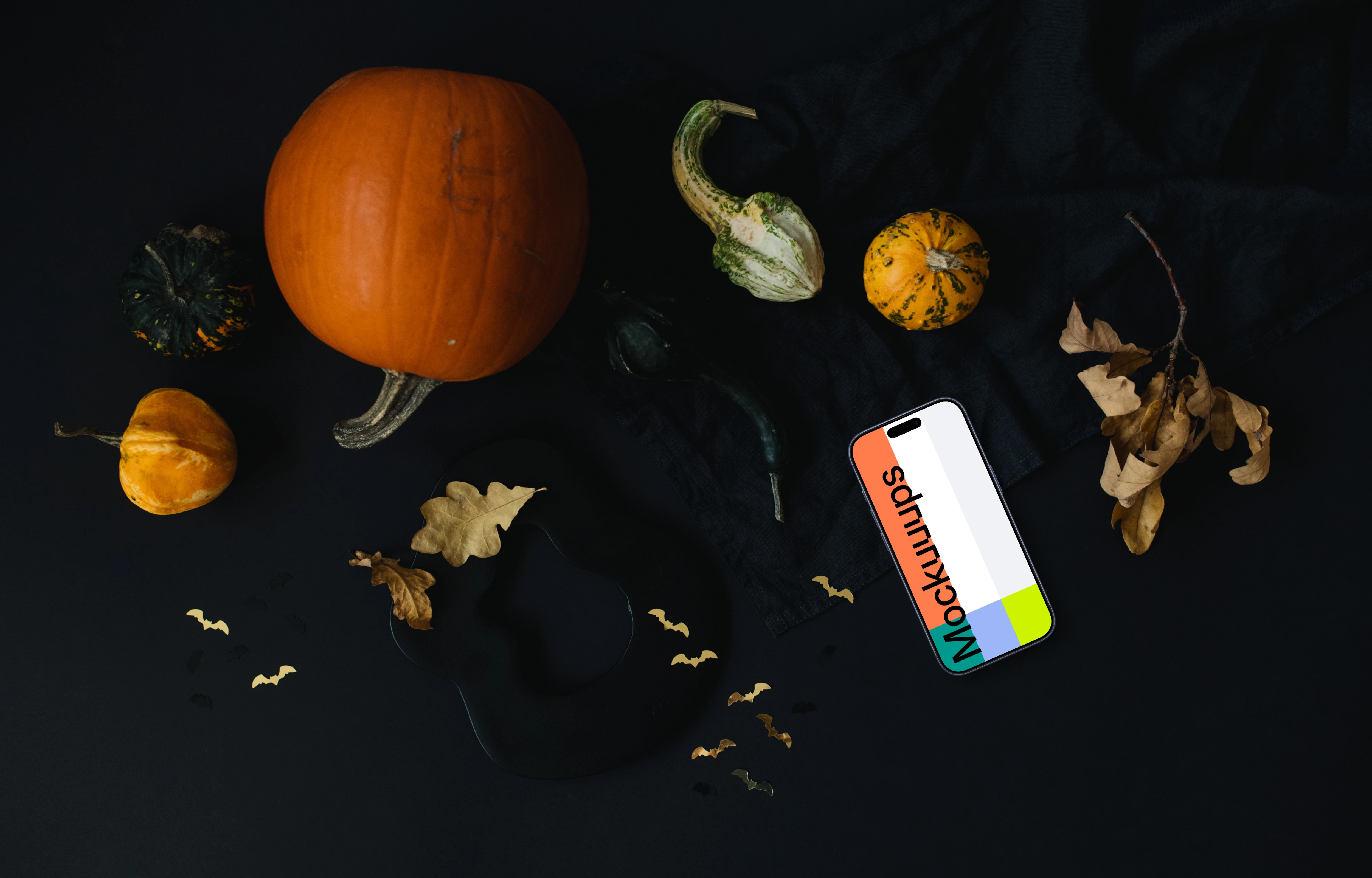 Halloween pumpkin mockup with a smartphone on the dark background