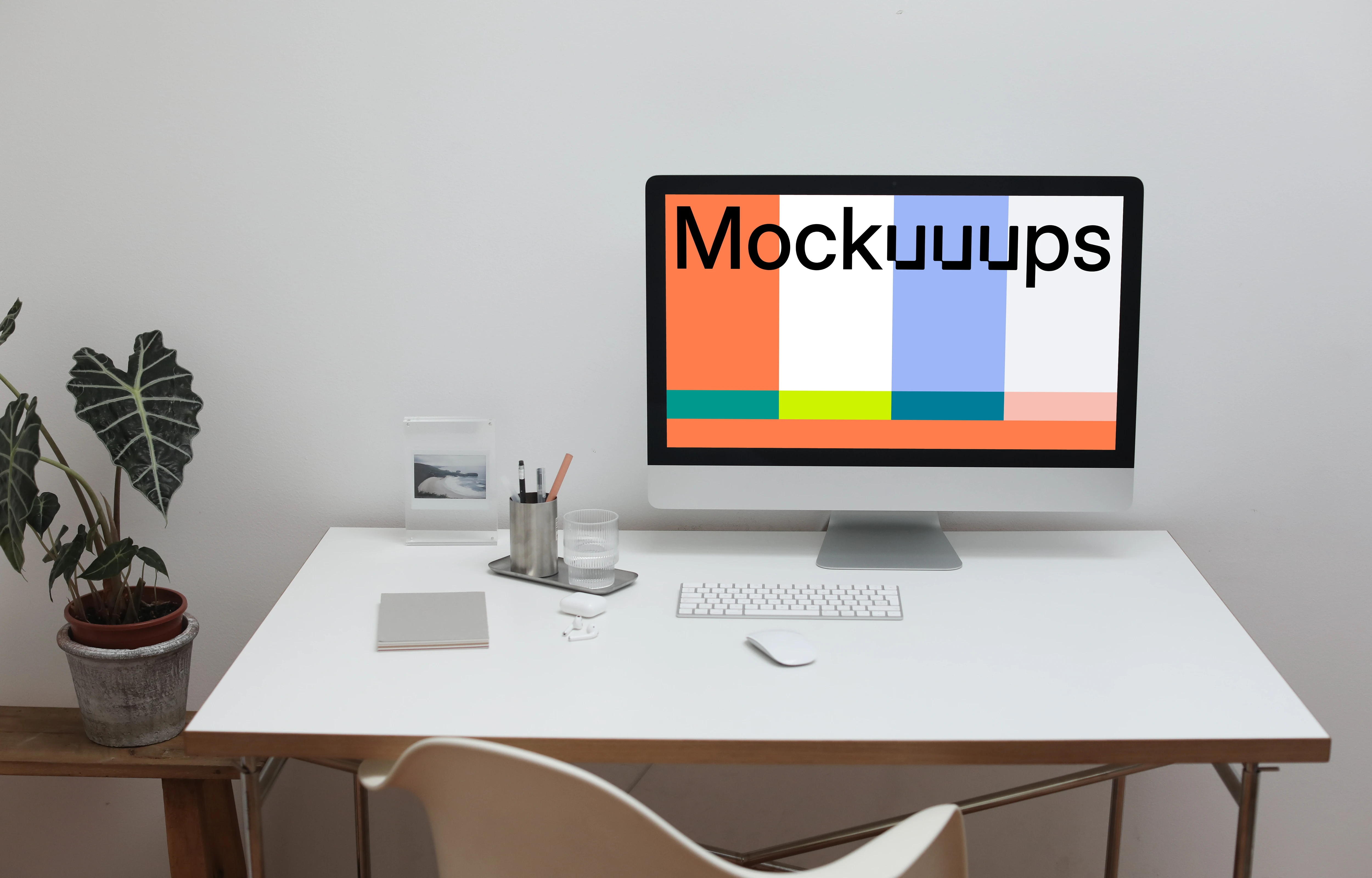 iMac mockup on a white table with a flower pot by the side