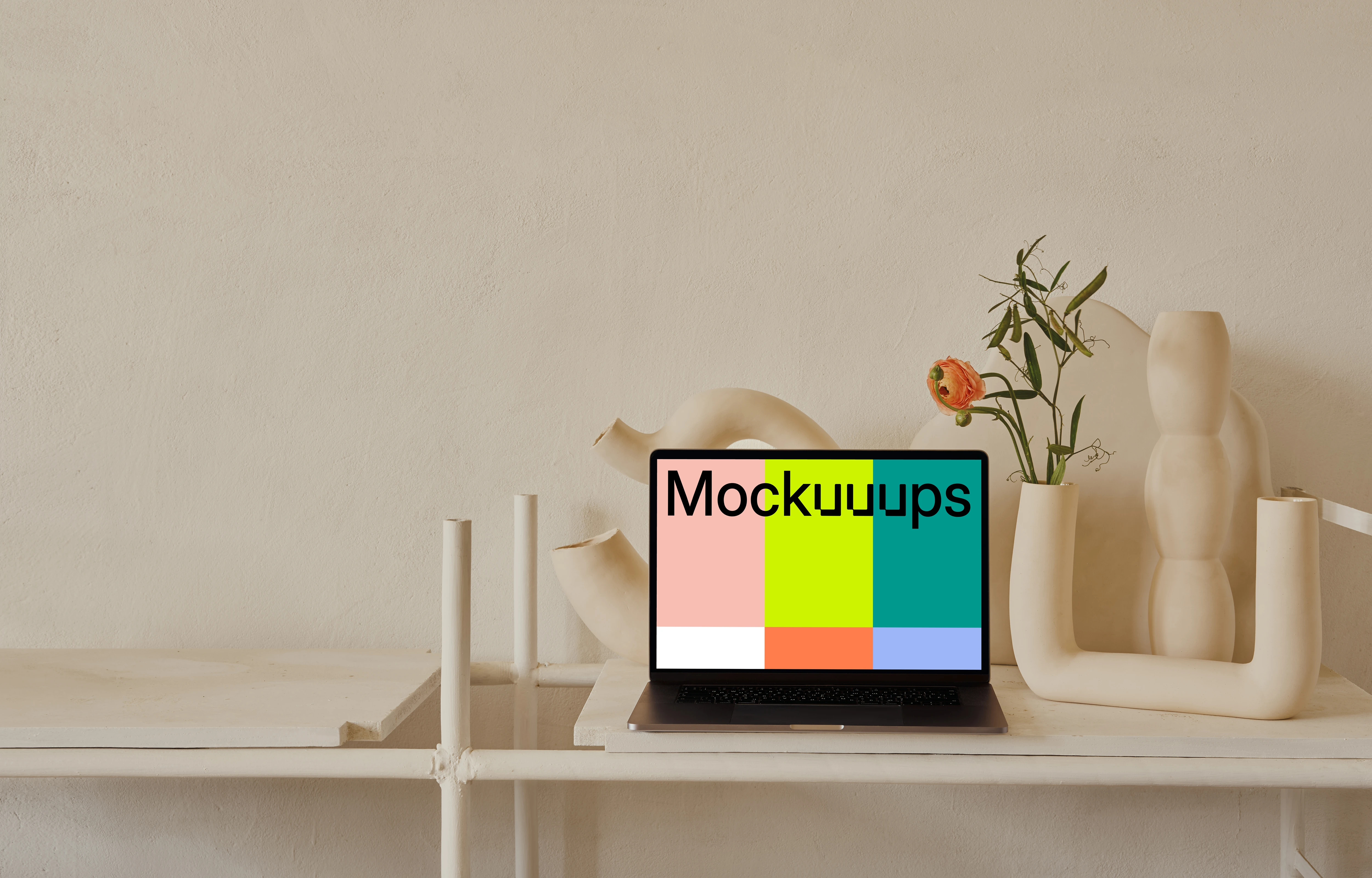 MacBook mockup on a table with peach coloured flower vase at the side
