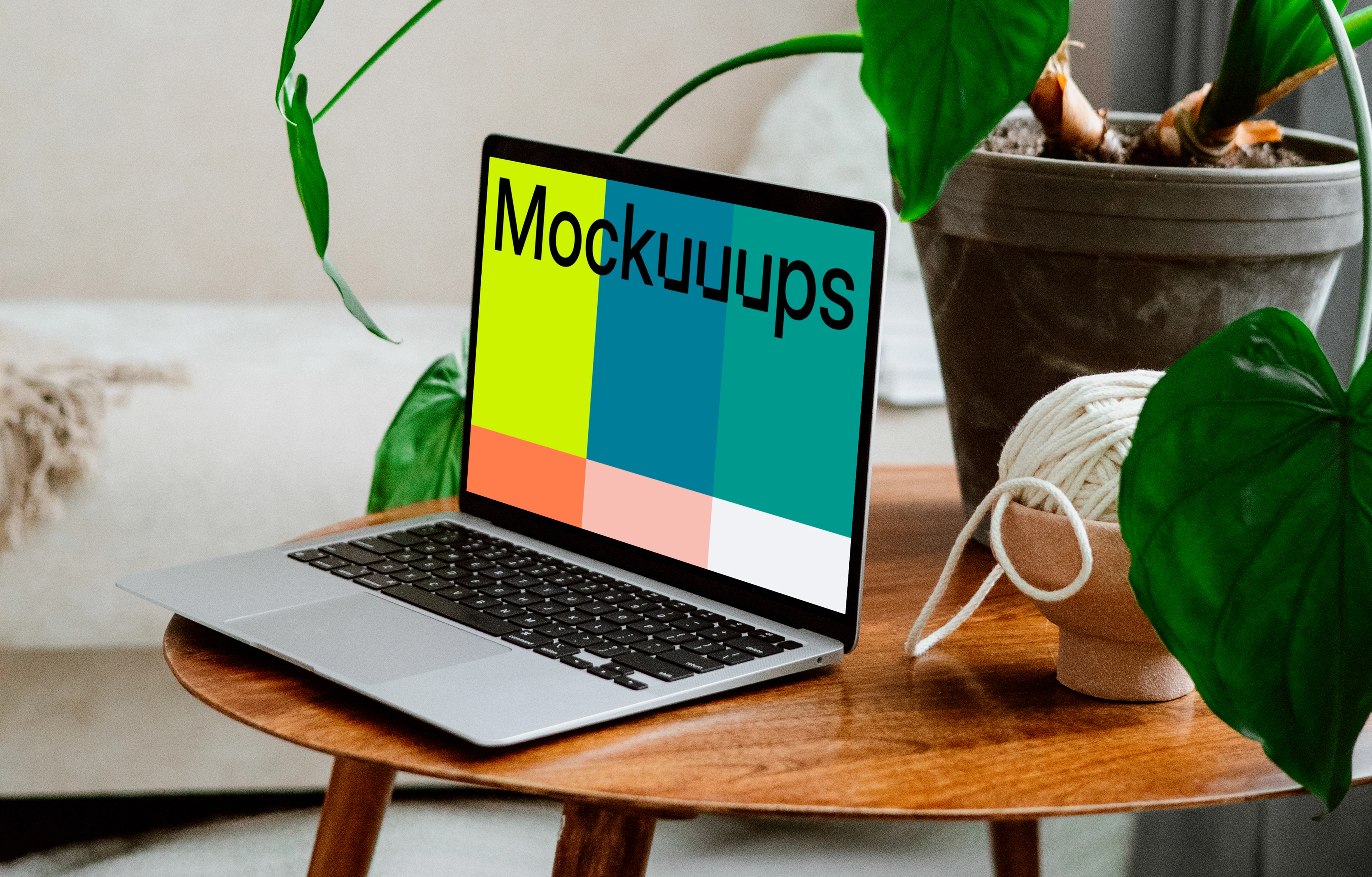 MacBook mockup on a wooden table with flower pot