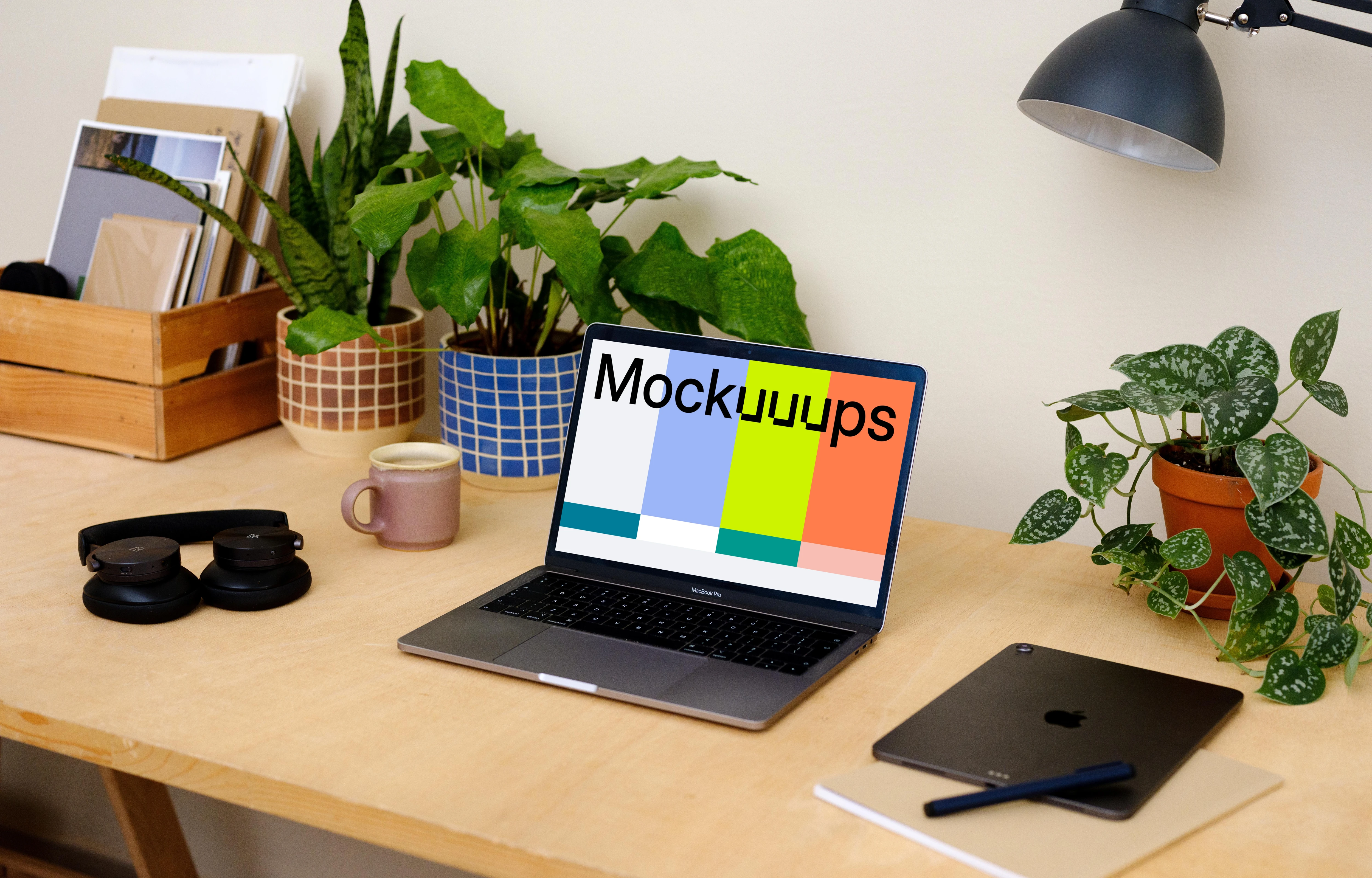 Macbook Pro mockup on a table beside a pair of headphones