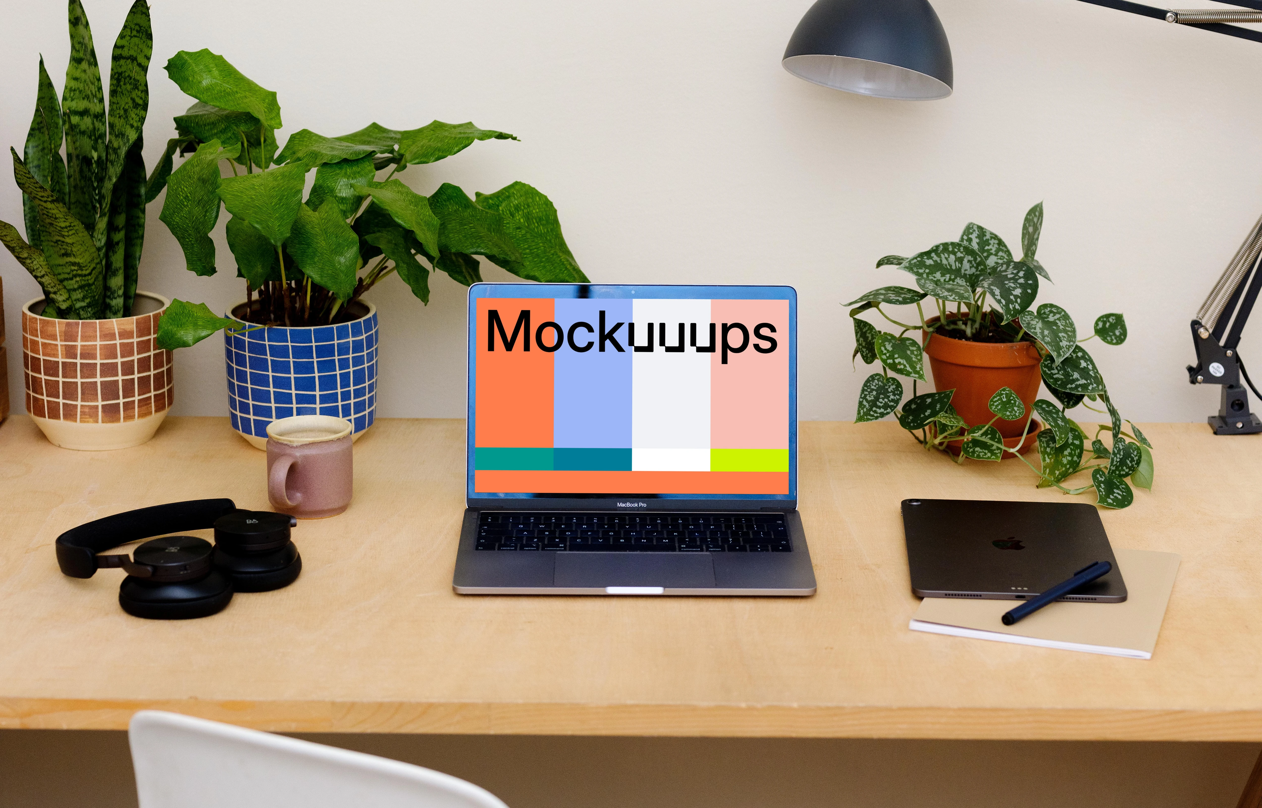 MacBook Pro mockup on a table with an iPad at the side.