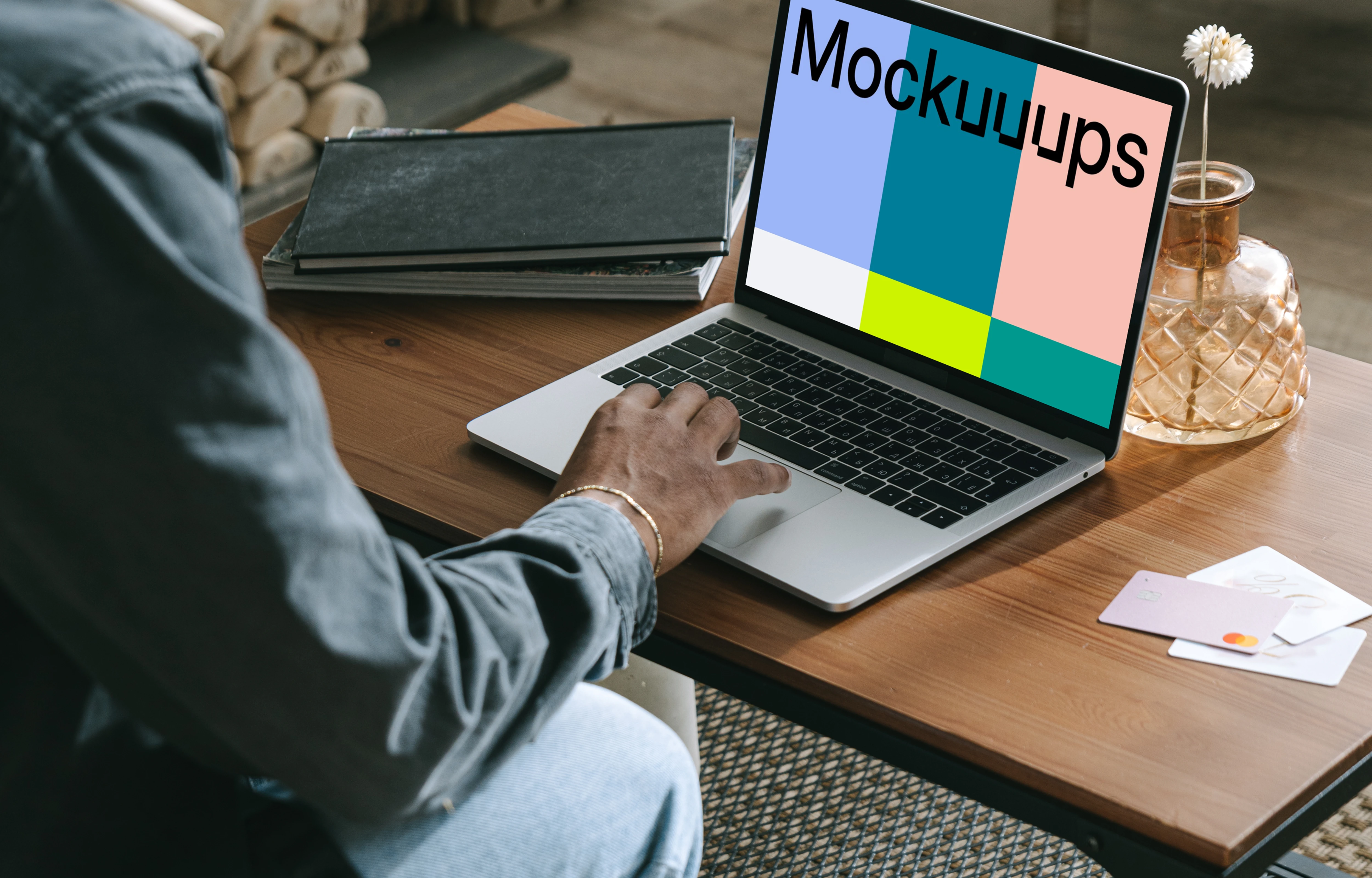 MacBook user shopping with a MacBook on the table and a debit card beside it mockup.