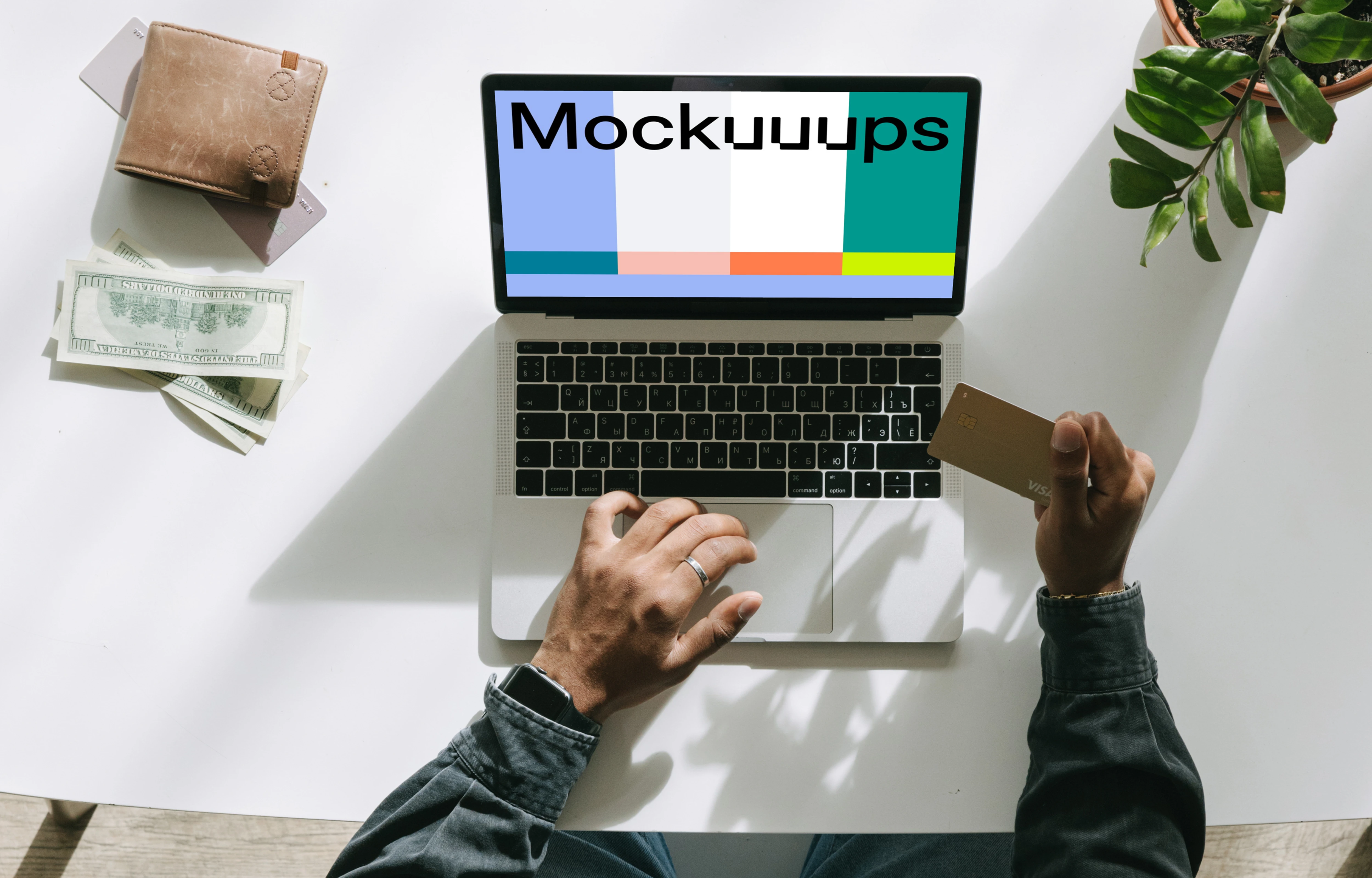 Mockup of User shopping on a Grey MacBook beside some cash and a wallet