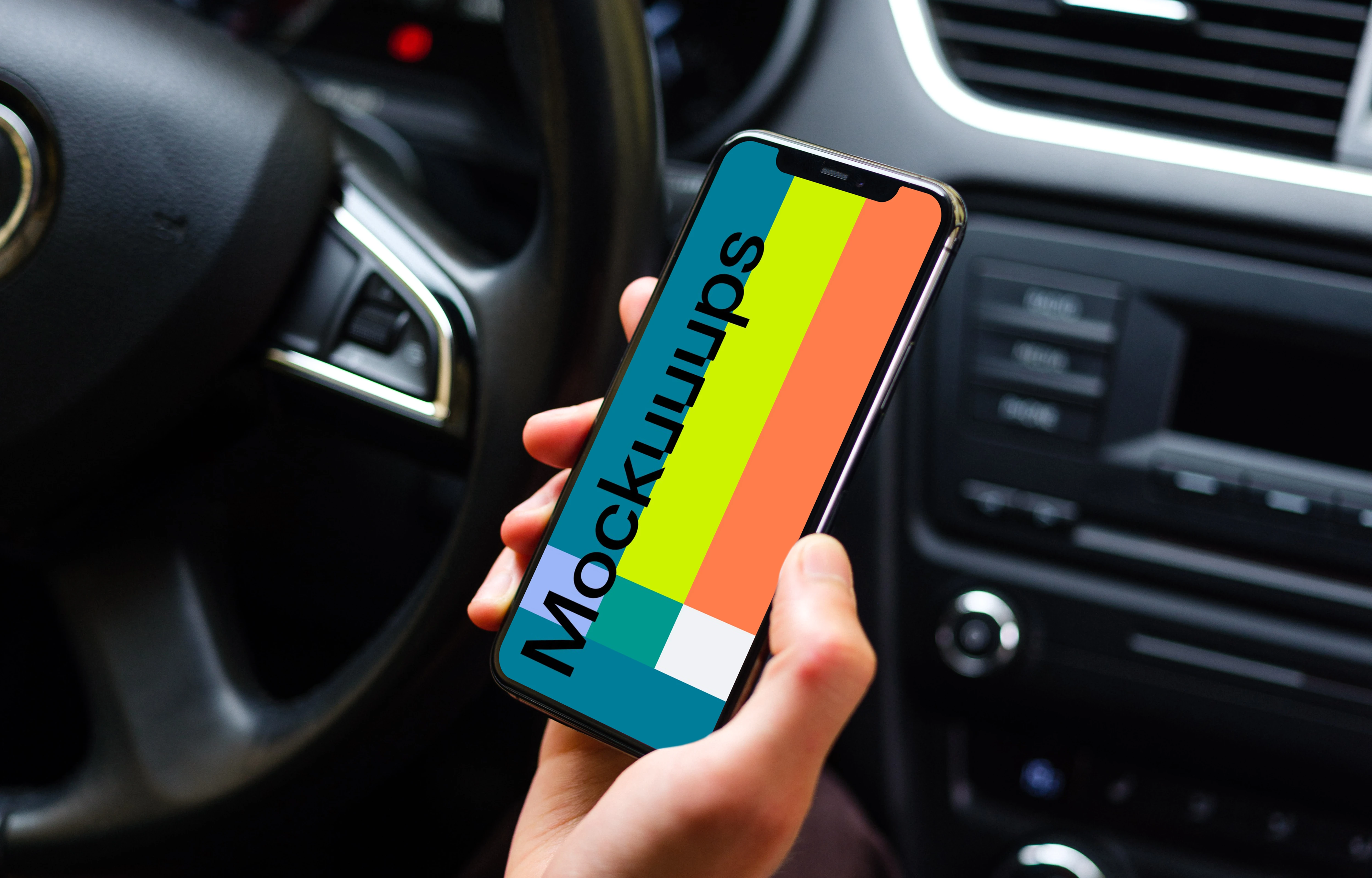 Drivers hand holding iPhone 11 mockup from behind the wheel