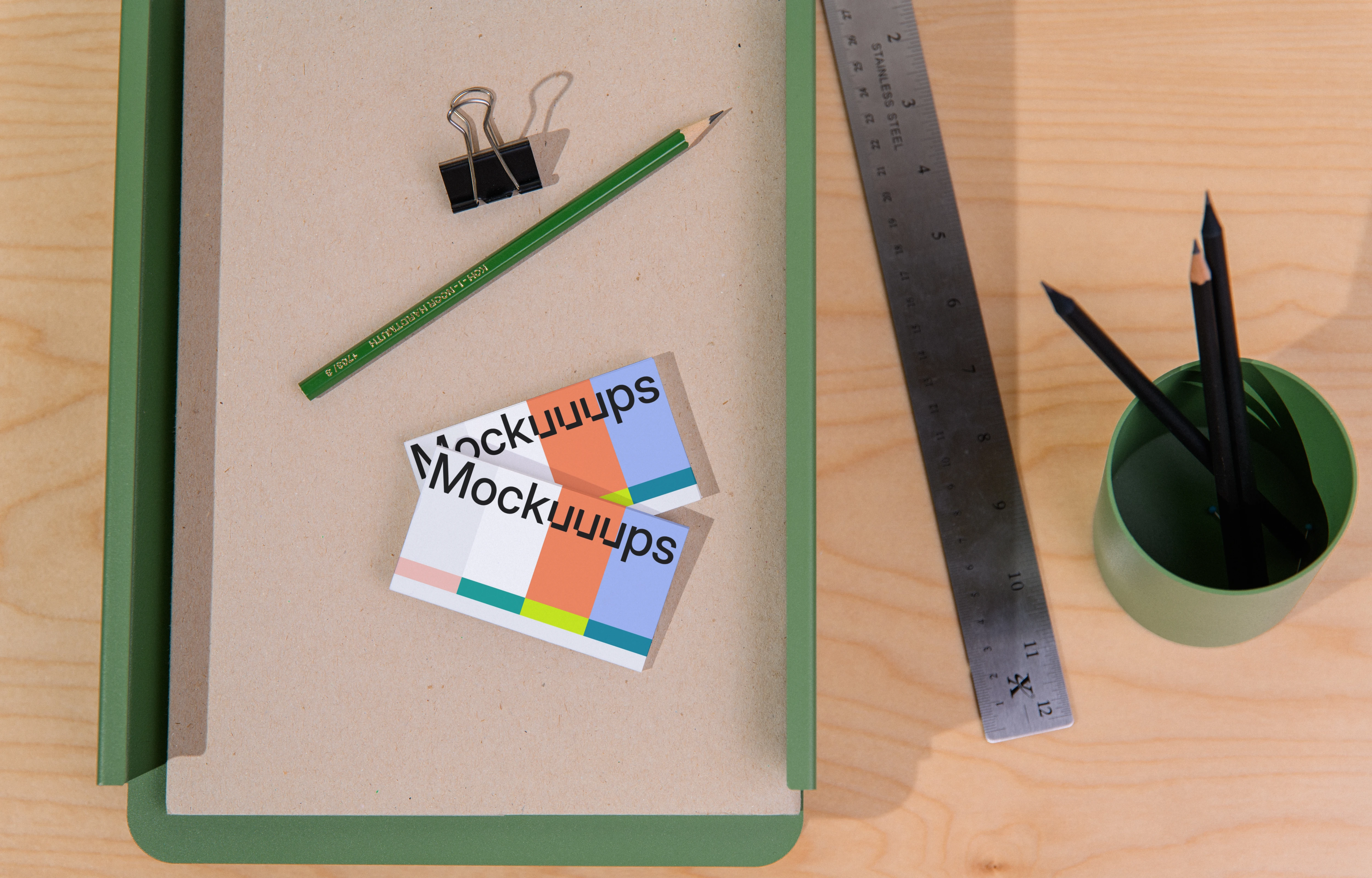 Two business card mockups on a desk with stationery