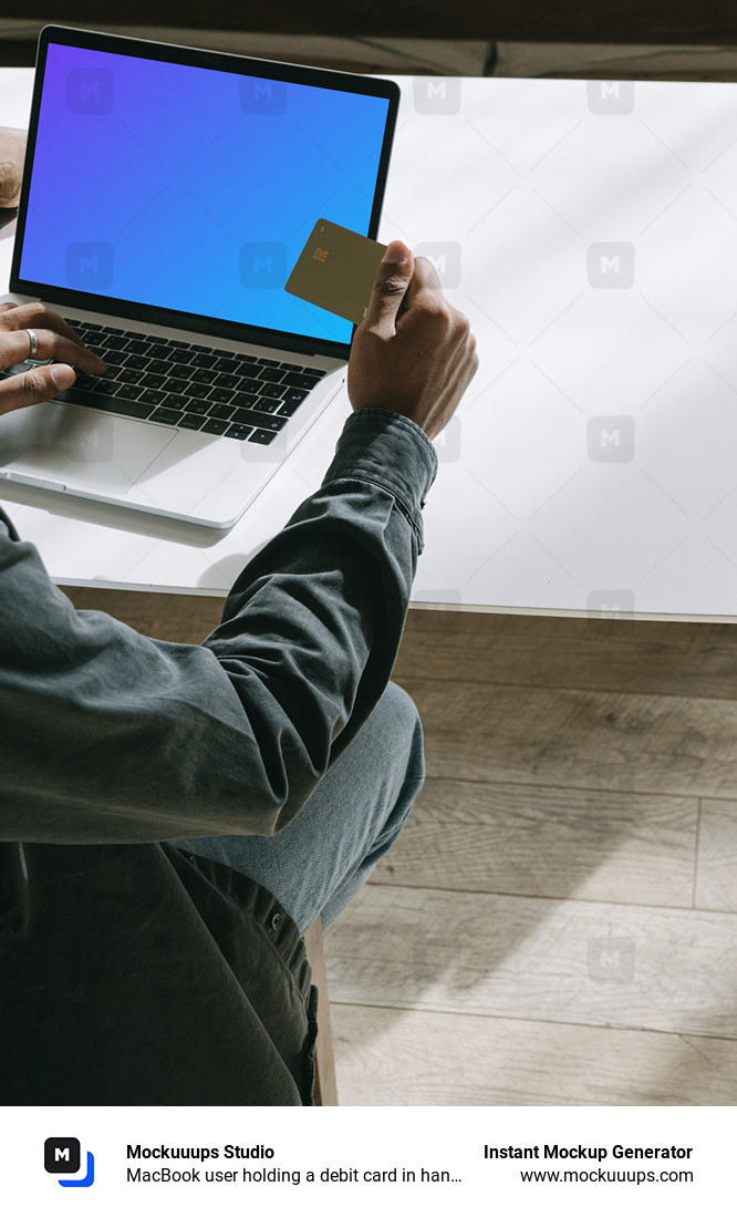 MacBook user holding a debit card in hand mockup.