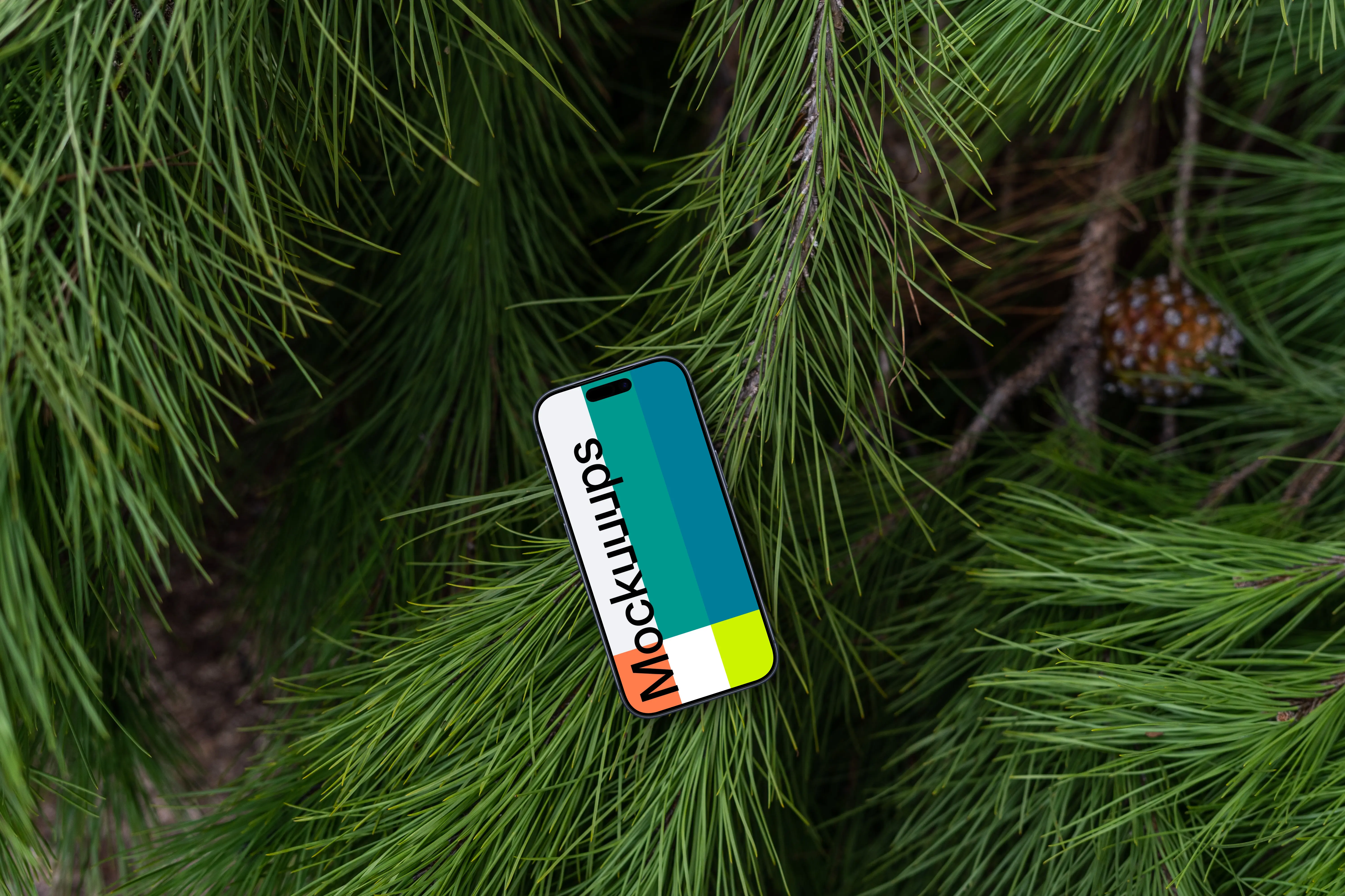 A smartphone mockup laying on top of a pine tree