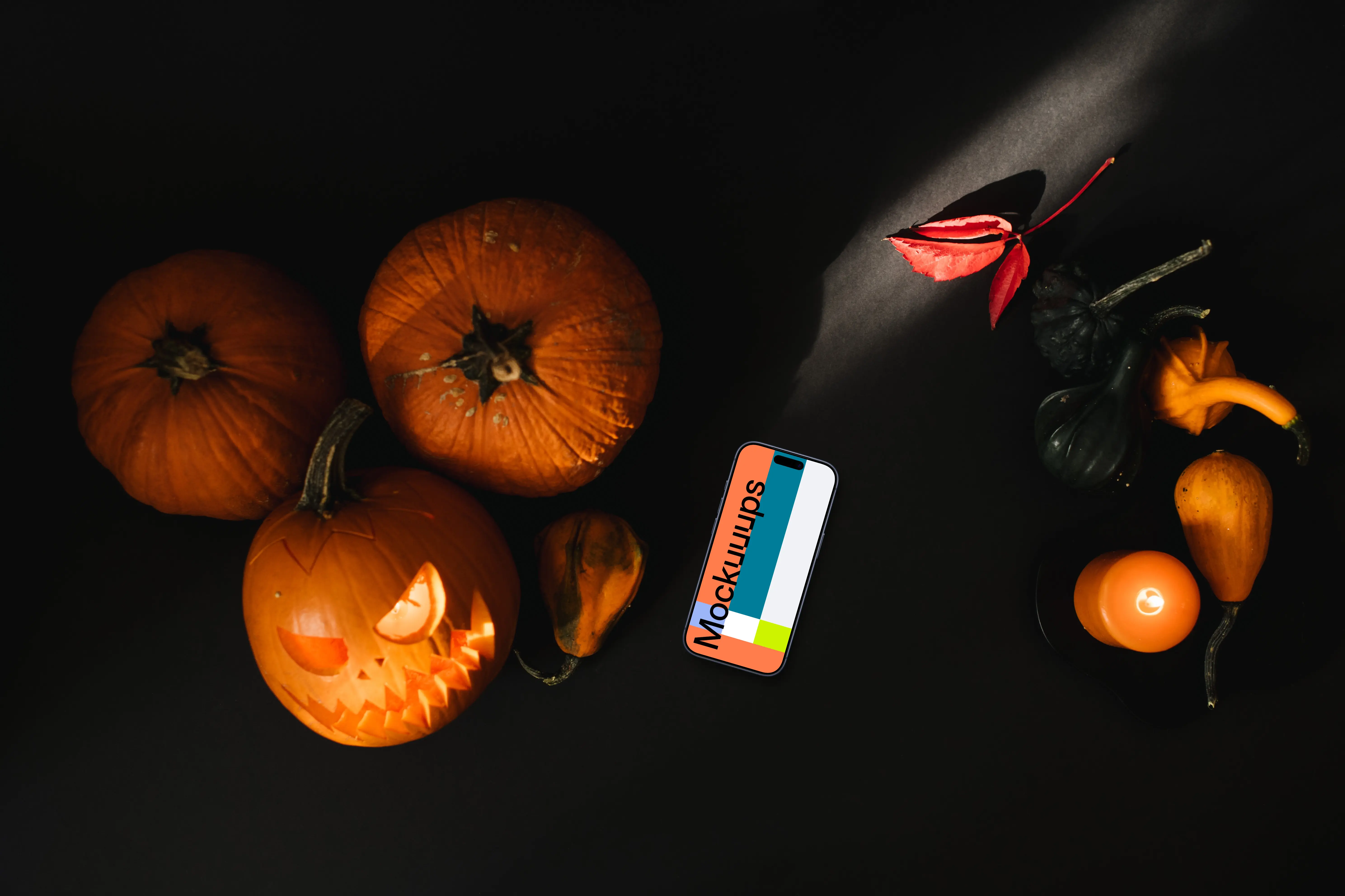 Halloween pumpkin mockup with a smartphone and candles