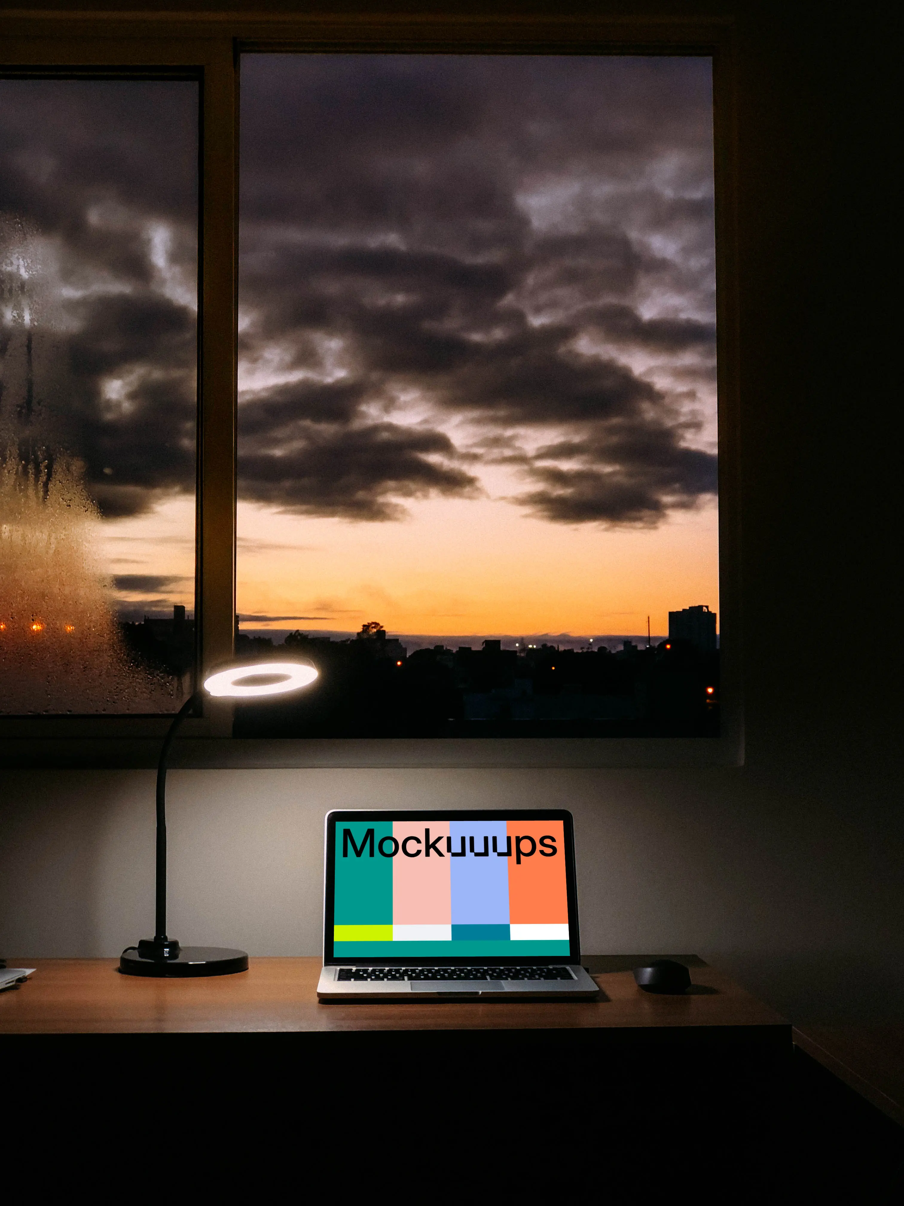 MacBook mockup at night with a reading lamp shining over it