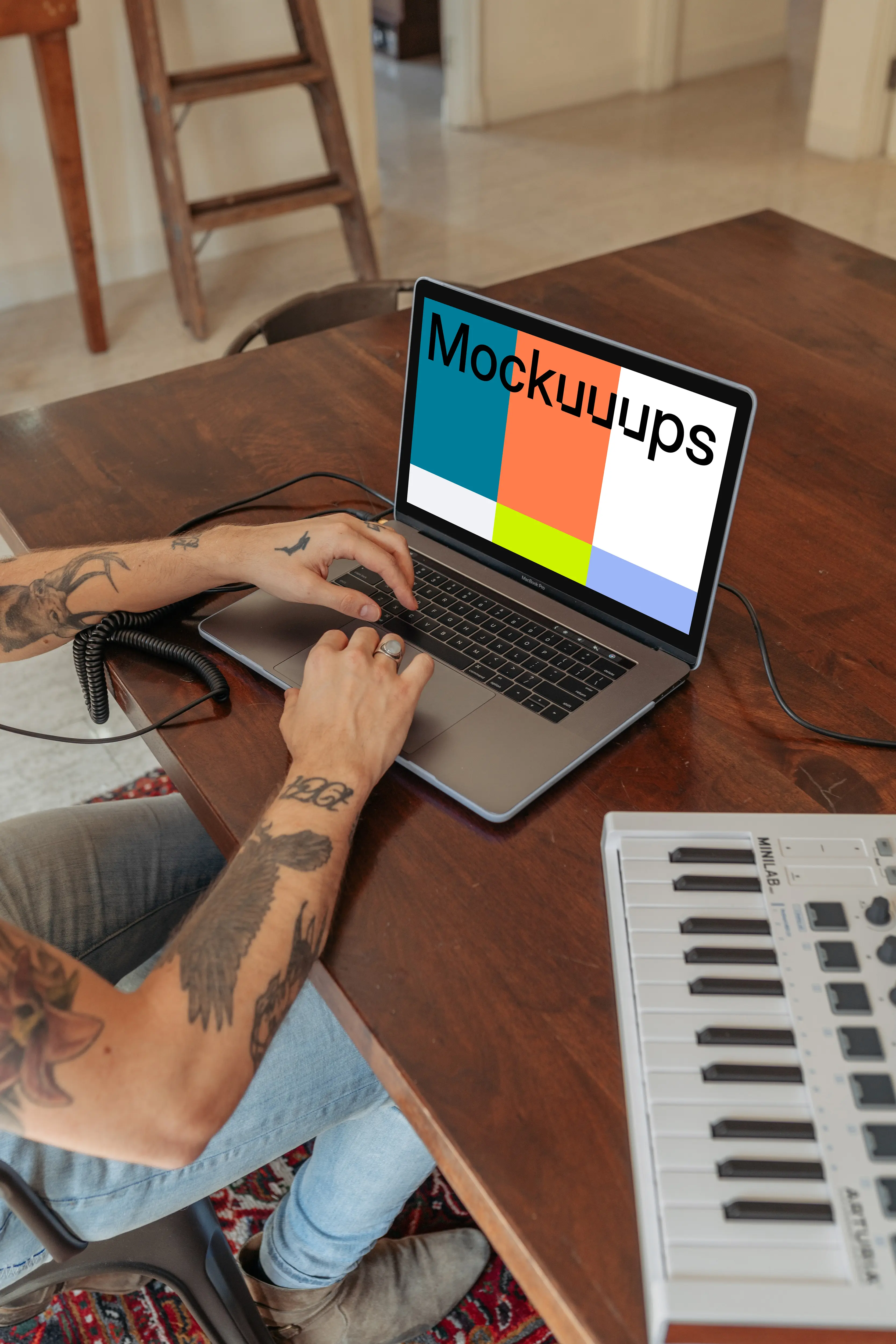 MacBook Pro mockup on a table with a mini-piano by the side