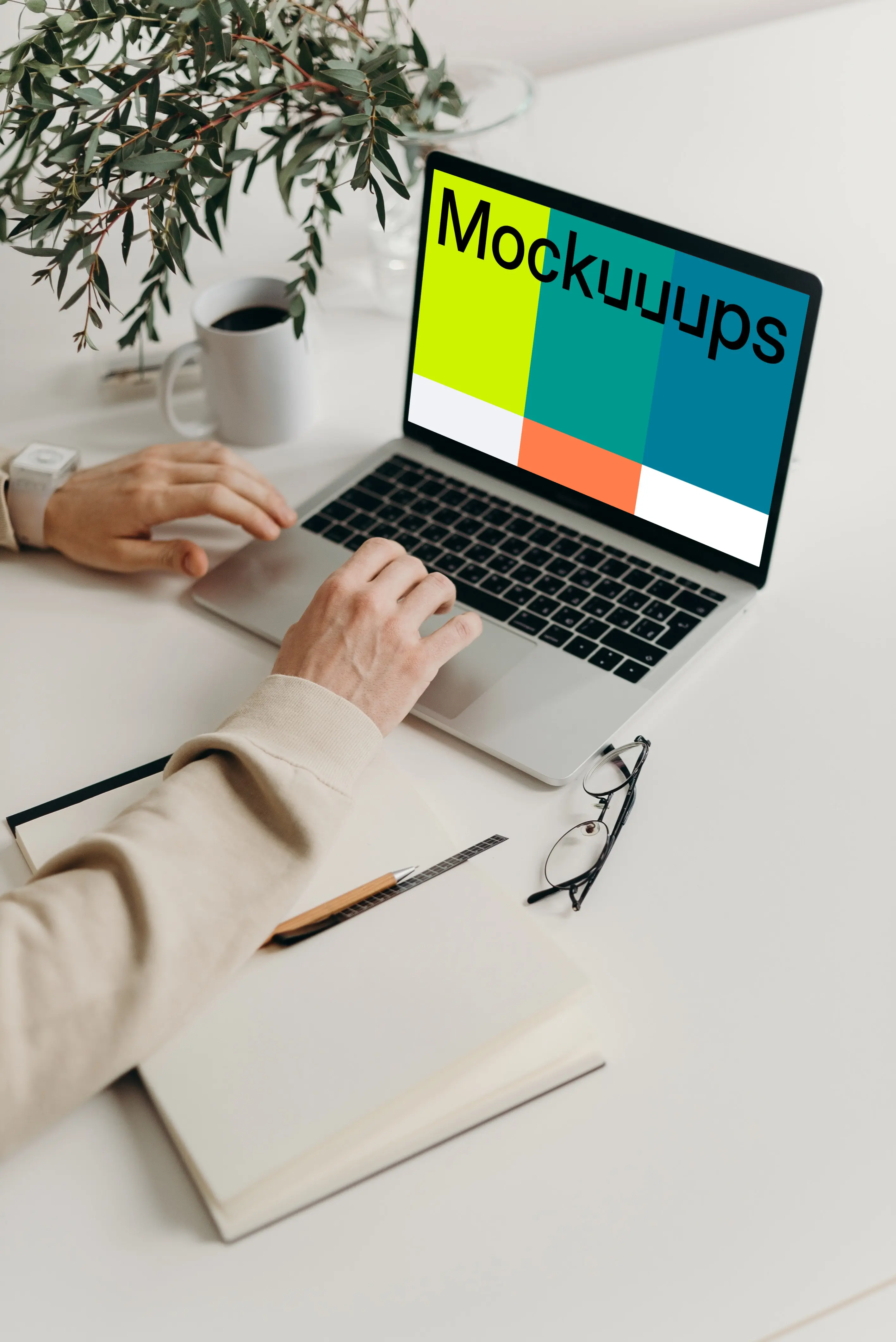 MacBook Pro mockup on a table with reading glasses by the side