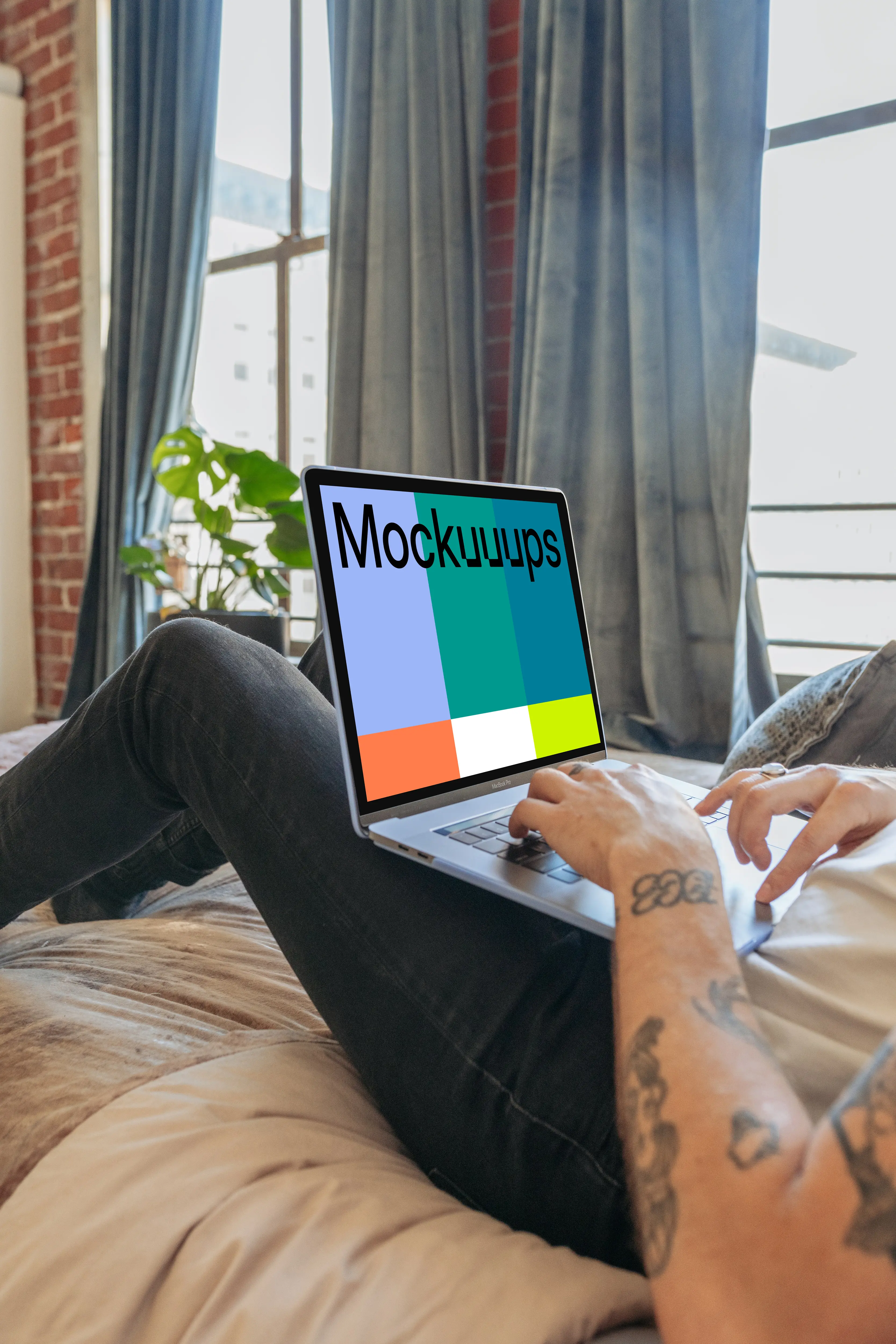 MacBook Pro mockup on man's legs in a bedroom