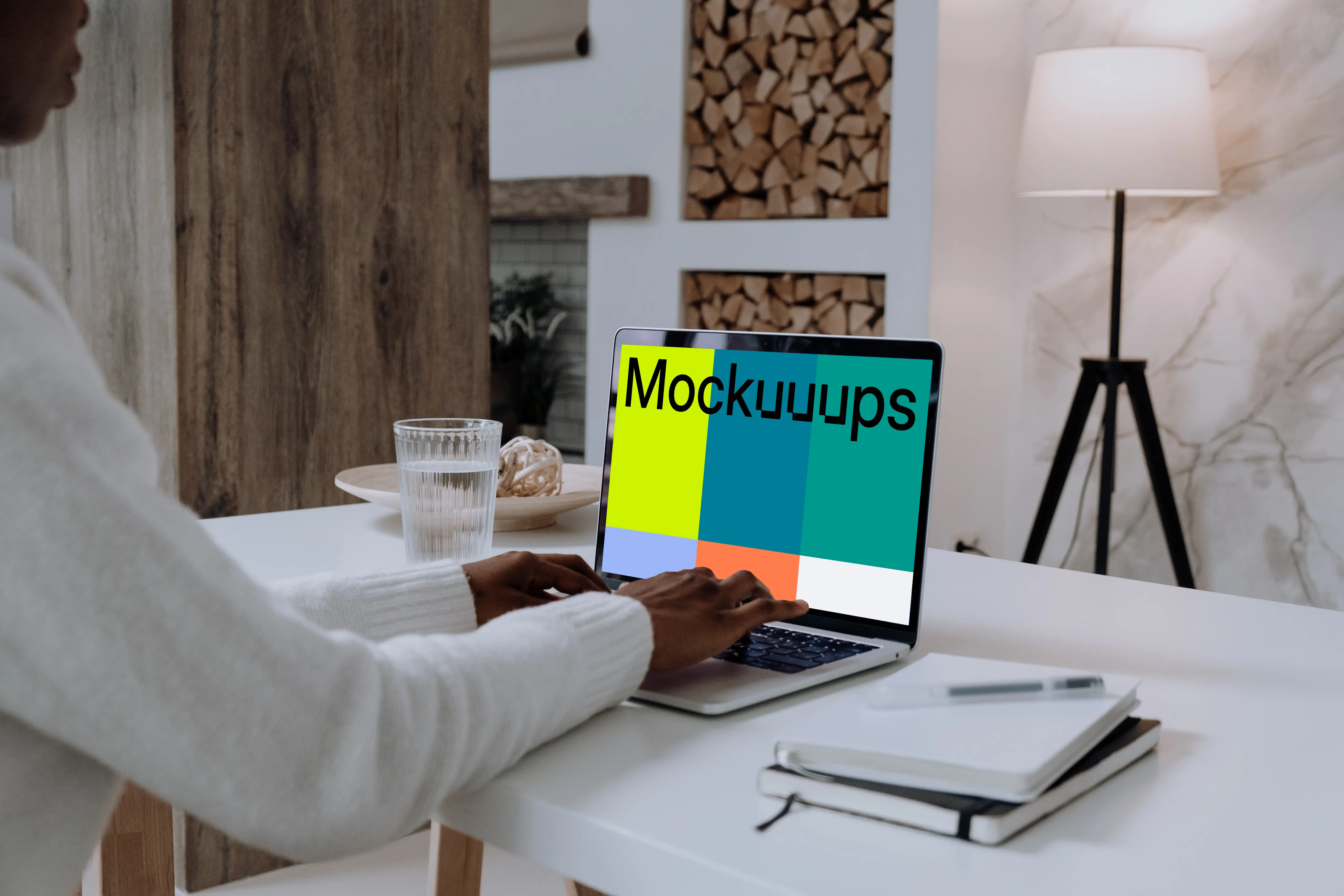 MacBook Pro mockup on white table with notebook by the side