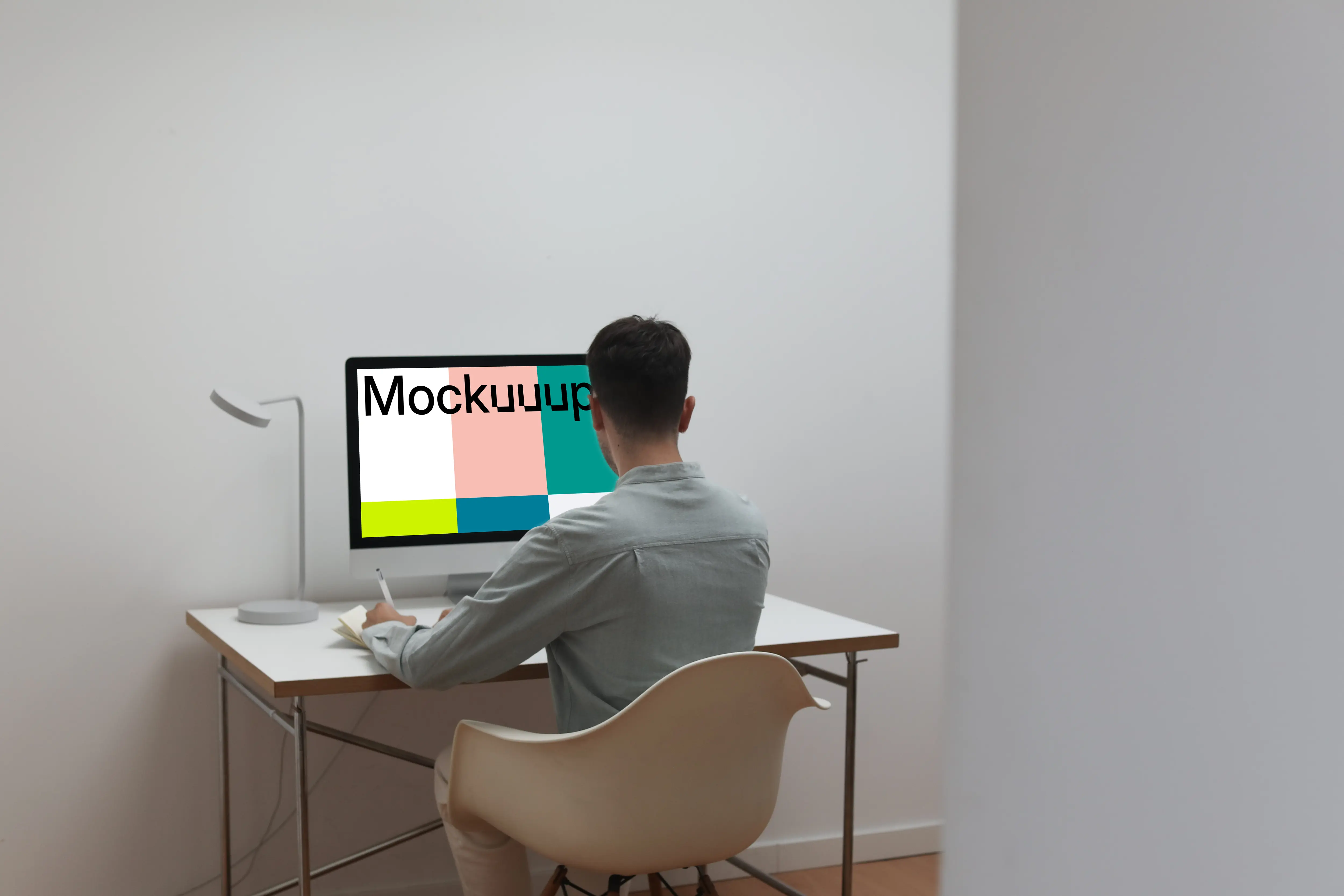 Man working on his iMac with his back to the camera